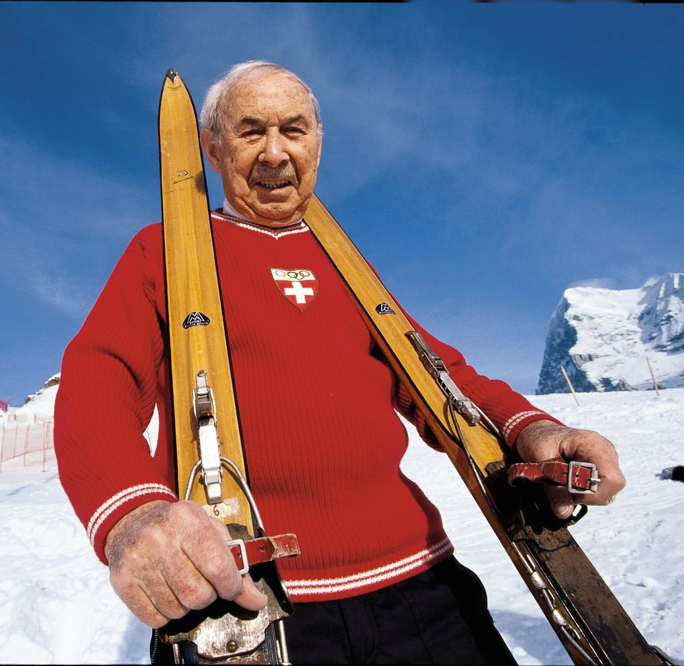 Wengen ski pioneer with wooden skis and a red Swiss sweater